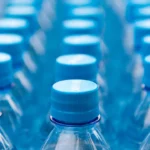 Borraccia termica riutilizzabile in acciaio arancione posizionata su un prato